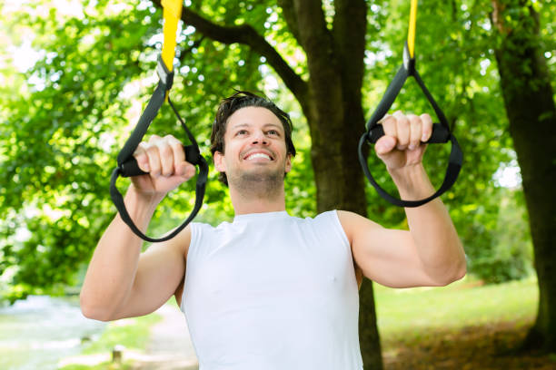 istock man in city park doing suspension trainer sport 829363444