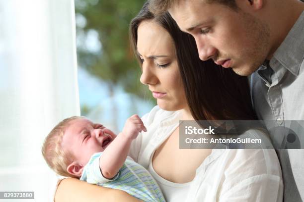 Tired Desperate Parents And Baby Crying Stock Photo - Download Image Now - Baby - Human Age, Crying, Parent