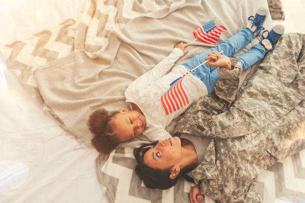 istock Mother in camouflage and her daughter lying on bed 829380176