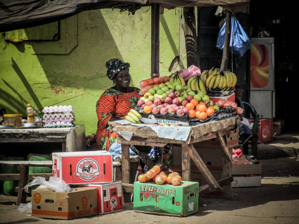 Senegalese traditional fruit shop Dakar, Senegal - May 28, 2011 - The streets of the suburbs of Dakar are populated by stalls selling all kinds of food. In this image it is a woman who sells fruit in her car senegal photos stock pictures, royalty-free photos & images