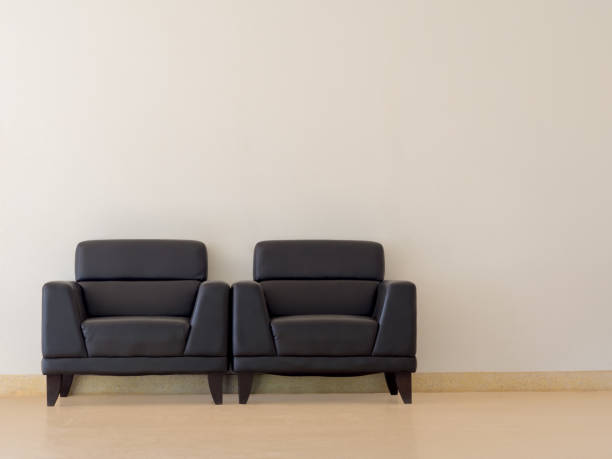 istock The black sofa is located in the room. There is a white concrete wall. 829381326