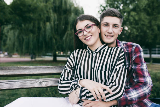 istock Loving couple sitting in a park 829386556