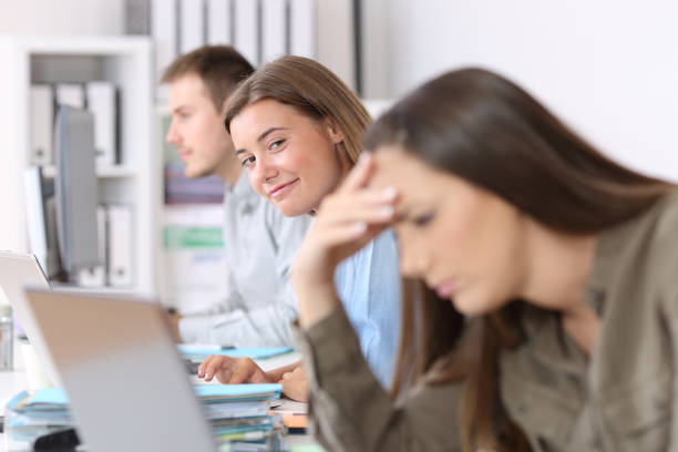 istock Happy worker looking at a frustrated colleague 829414688