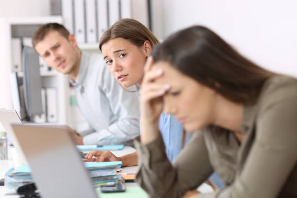 istock Sad workers looking at a frustrated colleague 829415256