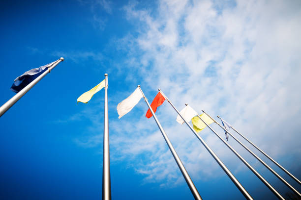 Triple empty flagpole against blue sky.