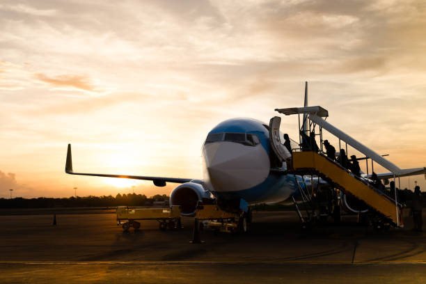 istock Passenger boarding on airplane in vacation in silhouette 829436520