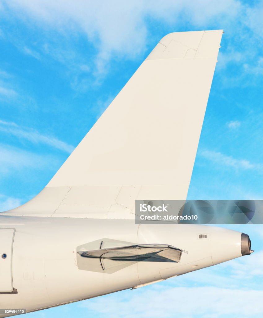 Plane tail fin - sky with white clouds in background Airplane tail fin - sky with white clouds in background Airplane Stock Photo