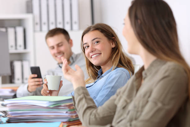 Happy customer service representatives communicating while working on computers in a call center.