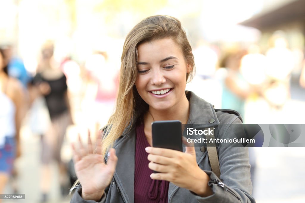 Saludo adolescente durante una videollamada - Foto de stock de Calle libre de derechos Saludo adolescente durante una videollamada - Foto de stock de Calle libre de derechos
