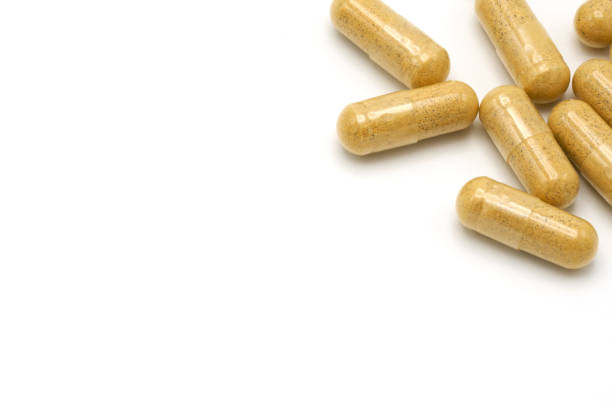 istock Capsule herbal medicine Inside is a powdered brown powder. Used for eating on white background. copy space. 829498018