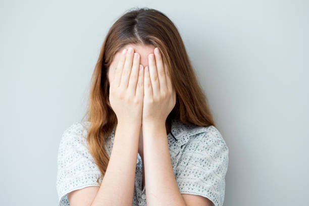 istock Shy girl covering up her face with her hands 829506502