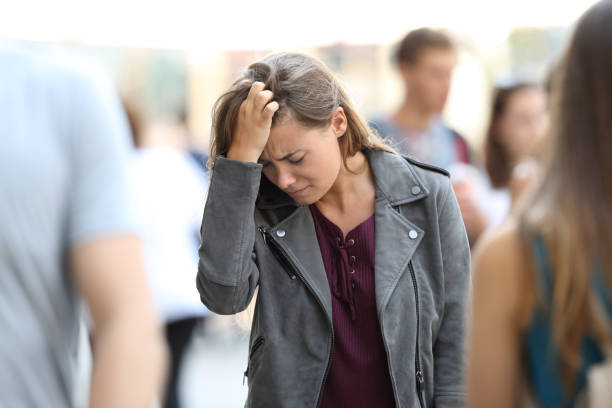 Depressed teen feeling lonely surrounded by people