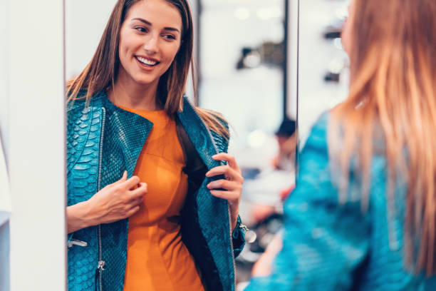 młoda kobieta w centrum handlowym ciesząc się skórzaną kurtką - mirror women dress looking zdjęcia i obrazy z banku zdjęć