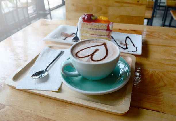 istock a cup of coffee and cake  on  wooden table with  light 829526852