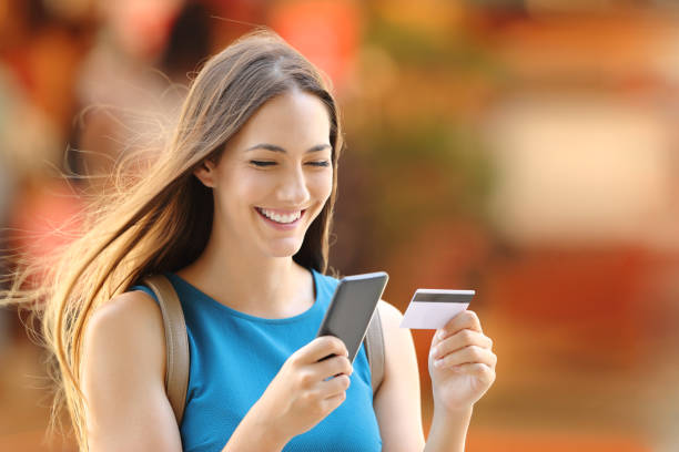 woman buying on line on the street - shopping e commerce internet credit card imagens e fotografias de stock