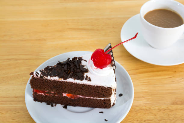 istock A slice of black chocolate cake with red cherry. 829527332