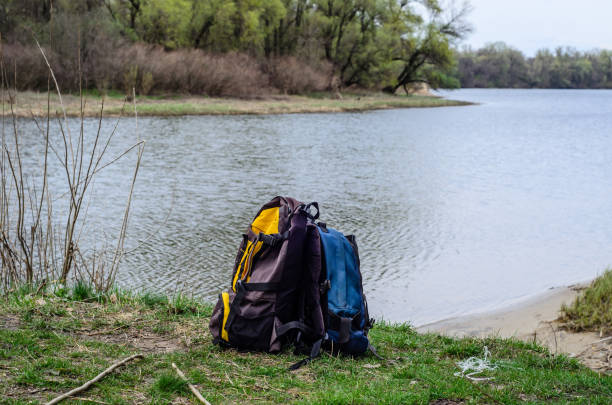 istock Backpacks on a bank of the river 829534926