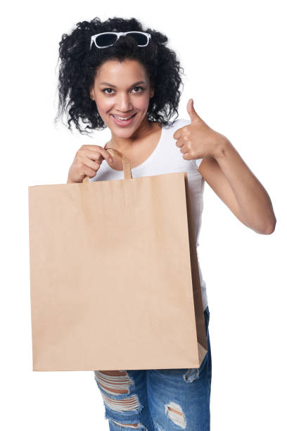 Woman holding sale shopping bags in park