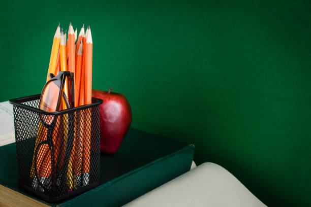 istock Books Pencil and apple on a white wooden table 829539928