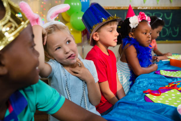istock Girl sticking out tongue while sitting with friends 829542190