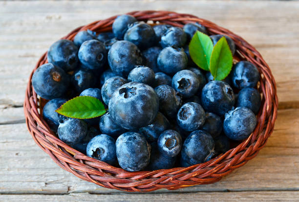 istock Fresh blueberries with green leaves in a basket on rustic table.Blueberry.Bilberry. 829548050
