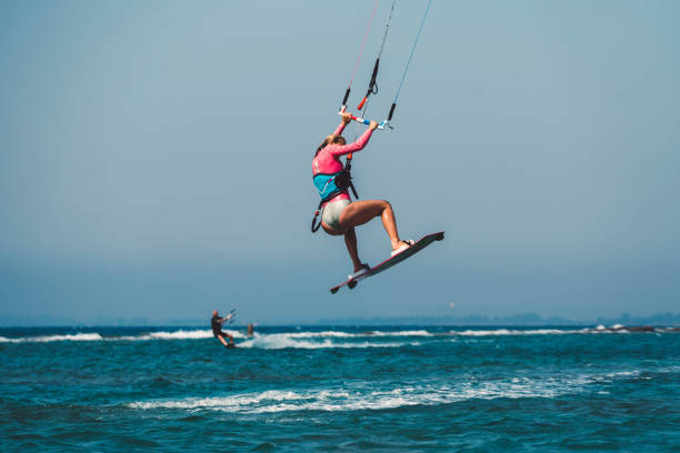 istock Young female kiteboarder in mid-air, rear view 829562714