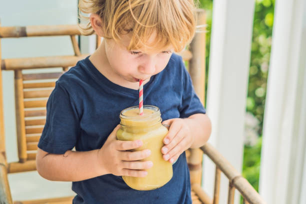 muchacho con un smoothie de plátano, el concepto de nutrición adecuada - oatmeal oat box container fotografías e imágenes de stock