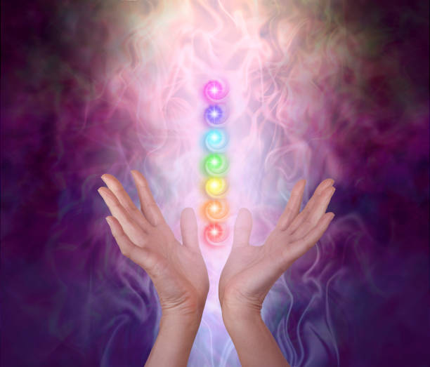 Working with the Seven Major Chakra Energy Vortexes Female healer's hands either side of seven chakra vortexes on an ethereal dark to light misty swirling energy field chakra photos stock pictures, royalty-free photos & images