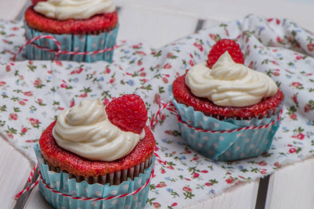 istock Red cupcakes with cream cheese frosting 829578812