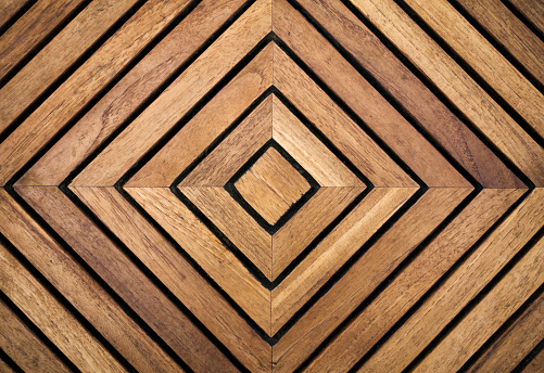 An abstract geometric pattern made by a square wooden table top.