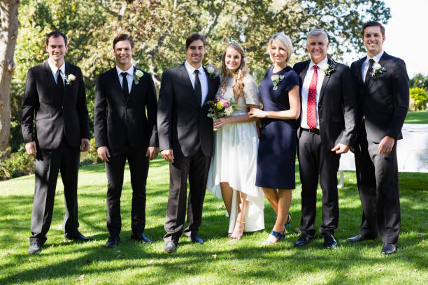 istock Bride and groom standing with guests 829615470