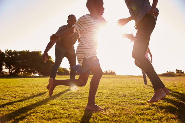 Young black family playing in a field in Summer