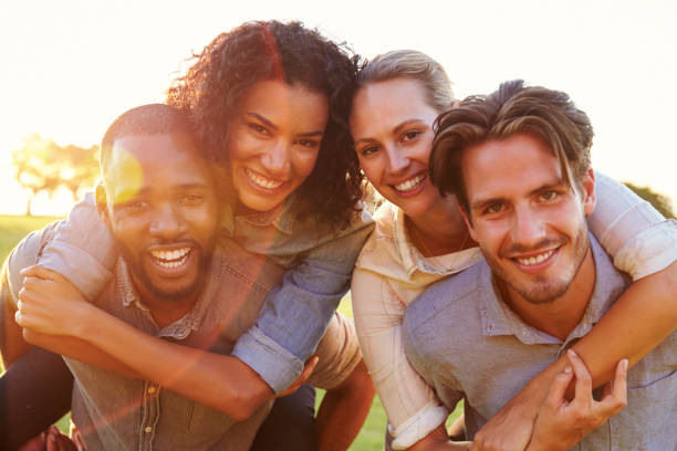 istock Two smiling couples piggybacking outdoors, close up 829619116