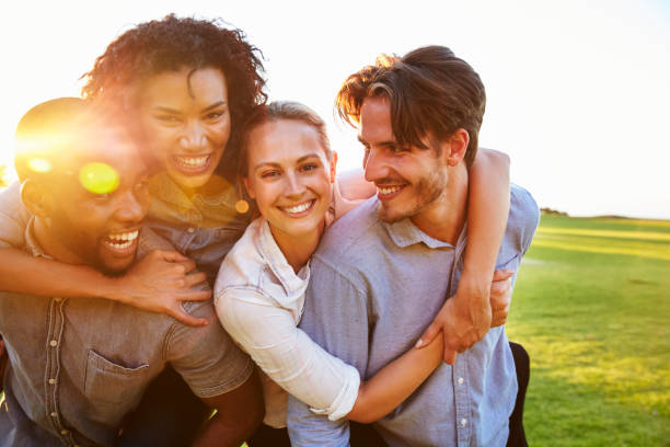 istock Two happy couples piggyback outdoors looking at each other 829619198