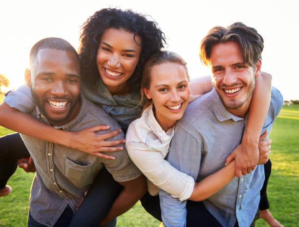 istock Two young couples having fun piggybacking outdoors 829619250