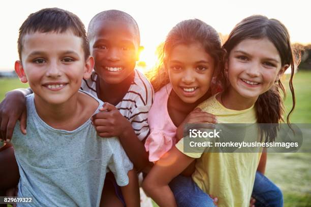 Foto de Retrato De Sorrindo Jovens Amigos Pegando Carona Ao Ar Livre e mais fotos de stock de Criança