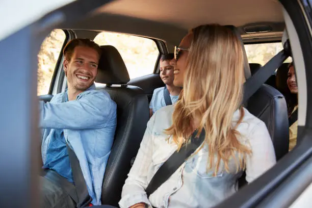 Photo of Young family with two children going on holiday in a car