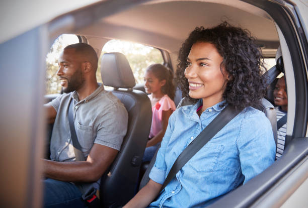 Young black family with children in a car going on road trip Young black family with children in a car going on road trip family in car stock pictures, royalty-free photos & images