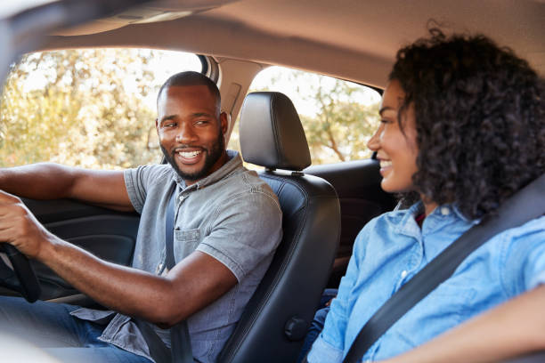 istock Young black couple in a car looking at each other smiling 829619878