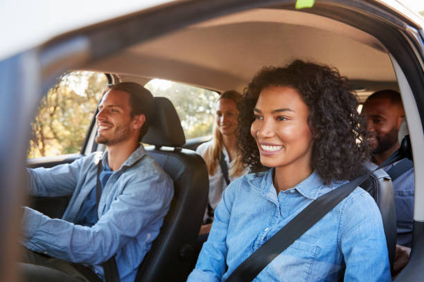 Four happy young adult friends in a car on a road trip Four happy young adult friends in a car on a road trip black men with blonde hair stock pictures, royalty-free photos & images