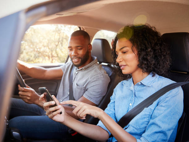istock Young black couple navigating with smartphone on a road trip 829624420