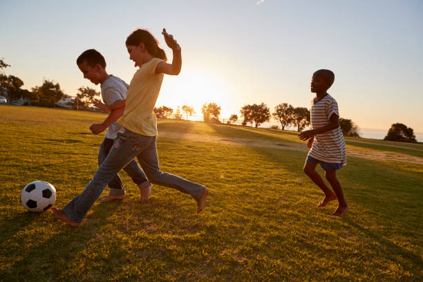 istock Three children playing football in a field 829630024