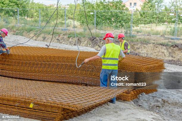 Workers Are Helping Mobile Crane To Pile Up Of Armature Rusty Square Reinforcement Stock Photo - Download Image Now