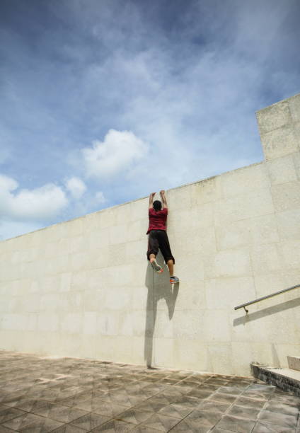 istock Young men climb up the wall,wall run jump 829648736
