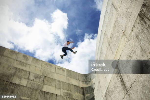 Young Man Stride Jumping On Concrete Wall Stock Photo - Download Image Now - Free Running, Agility, Risk