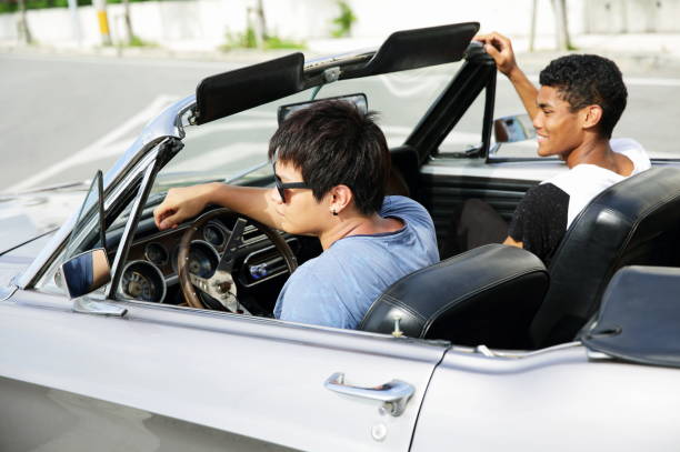 Young men driving in convertible car