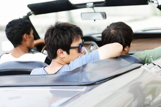 istock Young men driving in convertible car 829654642