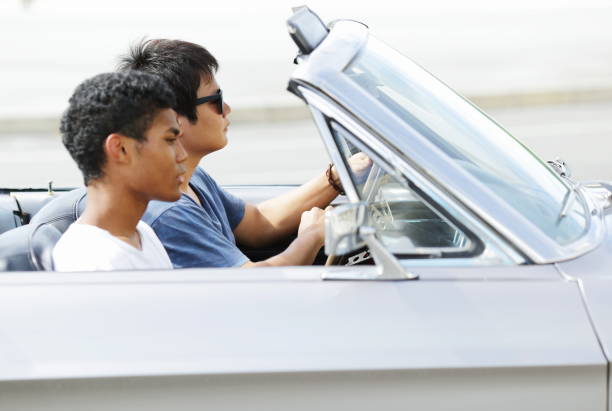 istock Young men driving in convertible car 829654704