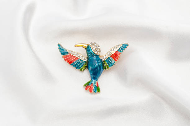 istock enamel brooch with Hummingbird and diamonds on silk fabric 829655730