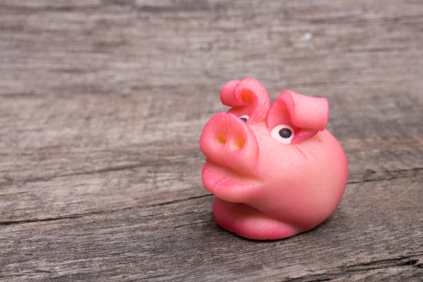 Pink marzipan pig on wood as closeup